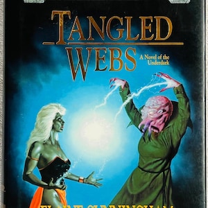 May include: A Forgotten Realms fantasy novel titled Tangled Webs by Elaine Cunningham. The cover features a white-haired figure in a black and orange outfit facing a pink-skinned creature in a green robe, with glowing light between them.