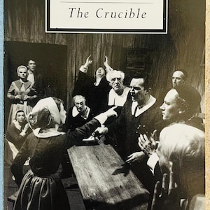 May include: Book cover for Arthur Miller's play, "The Crucible." The cover features a black and white photograph of a scene from the play, with actors in period costumes. The title and author's name are in white text.