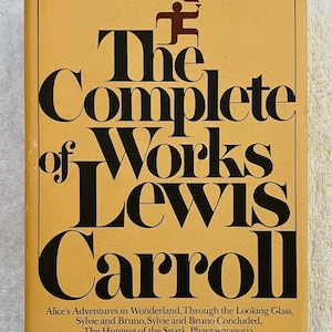 May include: A vintage book cover for "The Complete Works of Lewis Carroll" from the Modern Library. The cover is a mustard yellow with bold black lettering. The title and author's name are prominently displayed, with a small illustration at the top.