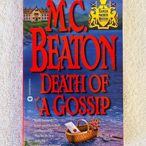 May include: A book cover for "Death of a Gossip" by M.C. Beaton. The title is in large, red letters against a blue background. A small basket with flowers and a fishing rod are in the foreground. The cover also features a quote from the Chicago Tribune.