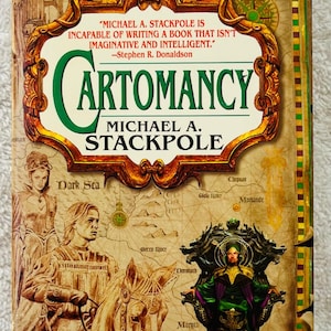 May include: A white ceramic mug with a black handle and the text "But First, Coffee" in a bold, black font. The mug is sitting on a wooden surface. The mug is approximately 4 inches tall.