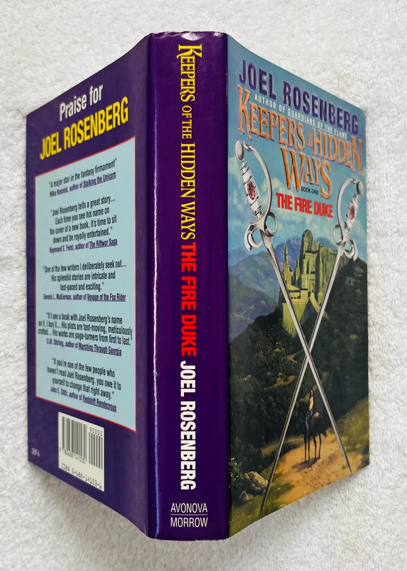 May include: A hardcover book titled "Keepers of the Hidden Ways: The Fire Duke" by Joel Rosenberg. The cover features crossed swords, a castle, and a person on horseback. The spine is purple with the author's name.