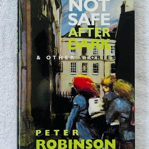 May include: A book cover for "Not Safe After Dark & Other Stories" by Peter Robinson. The cover features a street scene with figures and text in white and green against a dark background. The title is in large, bold letters.