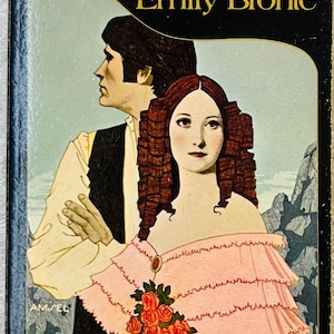 May include: A paperback book titled Wuthering Heights by Emily Brontë, an Enriched Classics Edition. The cover features an illustration of a person in a pink off-the-shoulder dress with a rose brooch and a person in a white shirt and black vest.