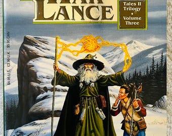 Könnte beinhalten: Buchcover von "Der Krieg der Lanze", Band drei der Dragonlance-Saga. Das Bild zeigt einen Zauberer und eine junge Person in einer verschneiten Szene. Autoren sind Margaret Weis und Tracy Hickman. Taschenbuch.