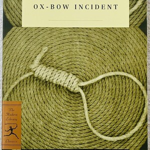 May include: The Ox-Bow Incident book cover. The cover features a quote by Clifton Fadiman, the title, and the author's name. The background is a textured, circular pattern with a rope noose.