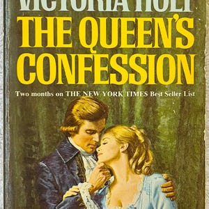 May include: A vintage paperback book cover for "The Queen's Confession" by Victoria Holt. The cover shows a romantic illustration of a couple embracing, with the title in large yellow letters. The cover also includes the text "Superb Romantic Bestseller" and the author's name.