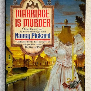 May include: Book cover for "Marriage is Murder" by Nancy Pickard. The cover features a sign with the title, a dress form wearing a pink dress, and a small gun. The background shows a town scene.