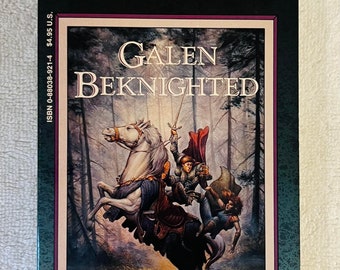 May include: A paperback book titled "Galen Beknighted" by Michael Williams, part of the Dragonlance Saga. The cover features a knight on horseback with a sword, set against a forest backdrop. The book is Volume Three.