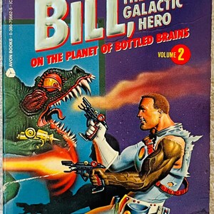 Op de afbeelding: Vintage paperback boekomslag voor "Bill, the Galactic Hero" van Harry Harrison en Robert Sheckley. De cover toont een sciencefiction-illustratie van een man met een straalwapen, een monster en de tekst "On the Planet of Bottled Brains, Volume 2."