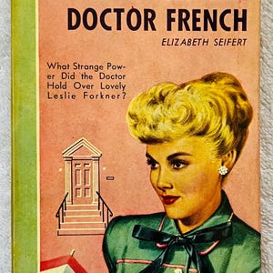 May include: Vintage paperback book cover for "A Certain Doctor French" by Elizabeth Seifert. The cover features a woman with blonde hair and a green jacket. Text includes the title, author, and "A Bantam Book."