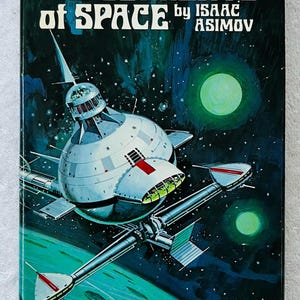 Könnte beinhalten: Vintage Science-Fiction-Buchcover für "The Currents of Space" von Isaac Asimov. Das Cover zeigt ein Raumschiff-Design in Weiß, Rot und Grün vor einem dunkelblauen und grünen Weltraumhintergrund. Der Titel ist weiß, der Name des Autors darunter.