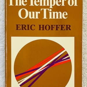 Puede incluir: Un libro de bolsillo vintage titulado "The Temper of Our Time" de Eric Hoffer. La portada es marrón con texto blanco y un diseño circular con líneas naranjas, rojas y moradas. El libro es de la Perennial Library.