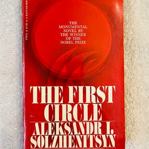 以下が含まれることがあります： アレクサンドル・ソルジェニーツィンの「The First Circle」というタイトルのヴィンテージペーパーバック。表紙は主に赤色で、白い文字と円形のデザインが特徴です。この本はBantam Bookで、Thomas P. Whitneyによって翻訳されました。