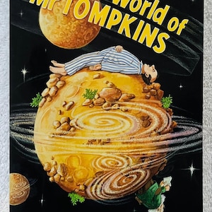 May include: Book cover for "The New World of Mr. Tompkins" showing a man in striped pyjamas on a planet. The title is in yellow, with the authors' names and illustrator's credit at the bottom. The background is black with stars and planets.