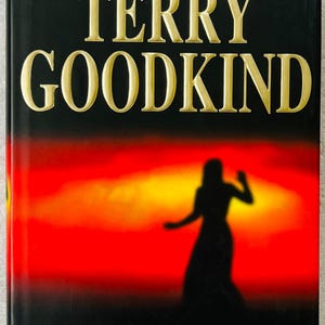 Puede incluir: Portada del libro "CHAINFIRE" de Terry Goodkind. La portada presenta una silueta contra un atardecer rojo y amarillo. El nombre del autor y el título están en letras doradas. El texto "New York Times Bestselling Author" está en la parte superior.