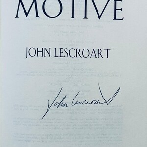 May include: A book cover with the title "THE MOTIVE" in dark blue capital letters. Below the title is the author's name, "JOHN LESCROART", also in dark blue. The author's signature is present, along with the publisher's logo and name, "DUTTON".