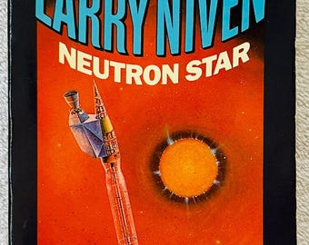May include: A vintage paperback book titled "Neutron Star" by Larry Niven. The cover features a rocket ship illustration against an orange and black space scene. Text includes "From the Solar System to the Galactic Core" and "A Del Rey Book".