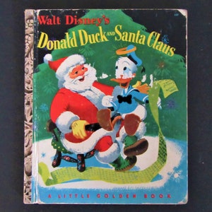 May include: A vintage Little Golden Book featuring Donald Duck and Santa Claus. The cover shows Donald Duck wearing a sailor outfit and Santa Claus sitting in a chair with a green and white patterned design. The book's title is "Walt Disney's Donald Duck and Santa Claus".