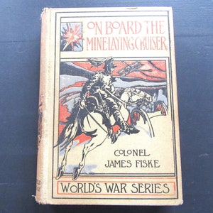 May include: A vintage book cover with a red, white, and blue illustration of a soldier on horseback. The title is "On Board the Minelaying Cruiser" by Colonel James Fiske. The book is part of the "World's War Series".