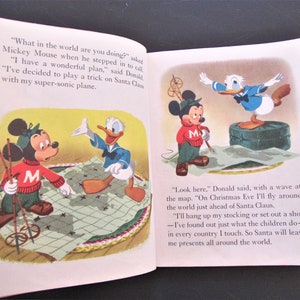 May include: Mickey Mouse and Donald Duck are planning a trick on Santa Claus. Mickey is holding ski poles and looking at a map of the world. Donald is standing on a suitcase and waving at the map. The text reads, "What in the world are you doing?" and "Look here. On Christmas Eve I'll fly around the world just ahead of Santa Claus."