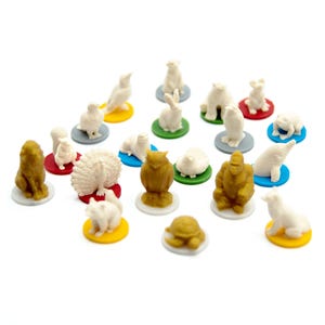 以下が含まれることがあります： ライオン、クマ、フクロウなど、小さな動物の形をしたフィギュアのコレクション。それぞれ小さな円形の台座に乗っています。動物たちは主に白、茶色、黄色です。