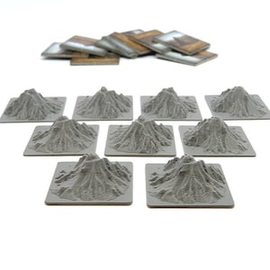 Peut inclure: Dix tuiles de montagne carrées, texturées et grises pour jeux de table. Chaque tuile présente un sommet de montagne surélevé et détaillé.