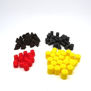 May include: An overhead shot shows four piles of game pieces. There are dark brown, tree-like shapes, black barrel-shaped pieces, red barrel-shaped pieces, and yellow cylindrical pieces. The pieces are arranged against a white background.