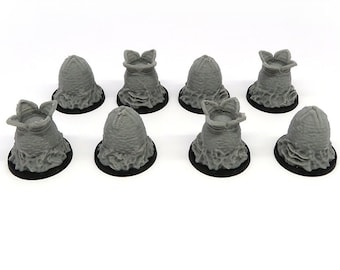 May include: Eight grey alien facehugger eggs on black bases. The eggs are open and the facehuggers are visible inside. The word "NEMESIS" is printed in white on a blue background.