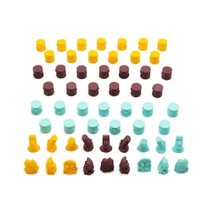 May include: A collection of colorful game pieces with different designs. The pieces are made of plastic and have a variety of colors, including yellow, brown, and blue. The pieces are arranged in a grid pattern.