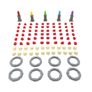 Puede incluir: Un conjunto de piezas de juego para un juego de mesa. Las piezas incluyen corazones rojos, anillos grises, cráneos blancos y torres grises con tapas de colores.