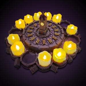May include: A circular dark gray stone-textured base featuring a central clock tower model surrounded by twelve slots. Ten yellow LED tea light candles are placed within the slots, emitting a warm glow. The base has a cobblestone pattern.