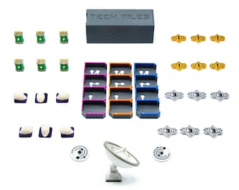 Könnte beinhalten: Eine Sammlung von Spielsteinen, darunter eine graue Box mit der Aufschrift "TECH TILES", farbige Tabletts und verschiedene Spielmarken. Die Teile sind auf weißem Hintergrund angeordnet, was auf ein Brettspiel oder ein Lernspielset hindeutet.