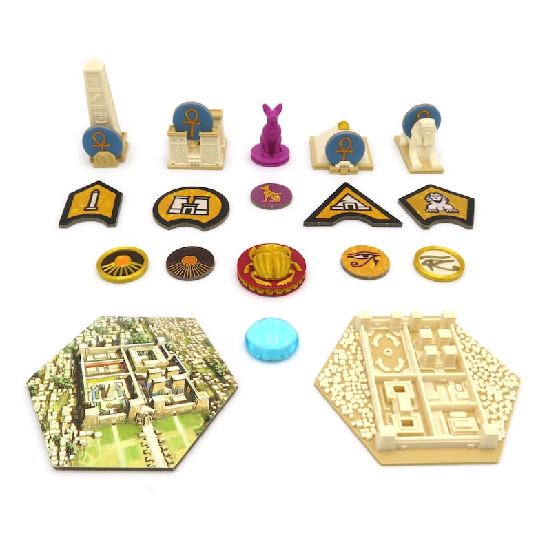 May include: A set of game pieces for a board game, including a pyramid, a sphinx, a temple, a scarab beetle, an eye of Horus, a sun disc, a jackal, a tower, a blue gem, and two hexagonal game boards.