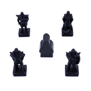 May include: Four black plastic game pieces, three are figures of warriors with swords and shields, and one is a simple shape. The pieces are on a white background.
