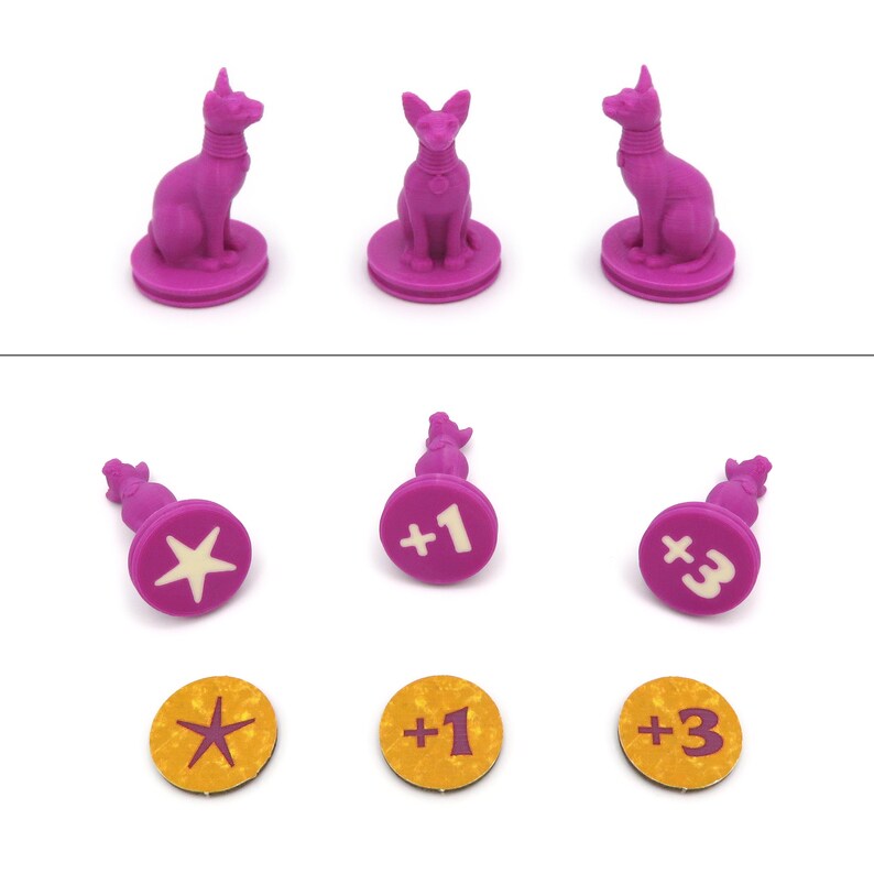May include: Three pink plastic game pieces featuring a cat figurine with a white collar and a star, plus one, and plus three symbols. The pieces are on a white background.