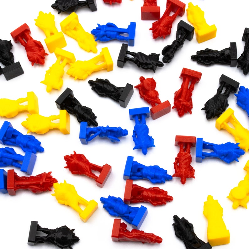 May include: A collection of colorful plastic game pieces in various shapes and colors, including red, blue, yellow, and black. The pieces are scattered on a white surface.