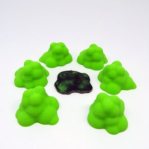 May include: Six bright green 3D printed miniature hills surround a dark green and black circular base.