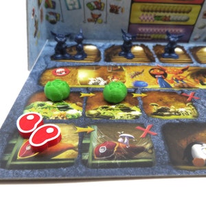 May include: A board game with green and red game pieces. The game board has a variety of illustrations, including a fish, a mushroom, and a penguin.