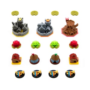 May include: A collection of colorful game pieces, including miniature castles, tree stumps, houses, tents, frogs, and trumpets. The pieces are in various colors, such as gray, brown, red, and yellow, and are arranged on a white background.