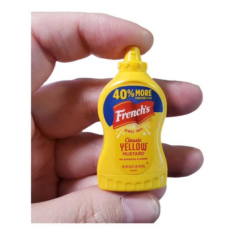 May include: A yellow plastic squeeze bottle of French's Classic Yellow Mustard. The bottle has a yellow cap and a label with the text "40% More Than Our 14 oz." and "French's Since 1904 Classic Yellow Mustard No Artificial Flavors Net Wt 20 oz (1.18 kg)"