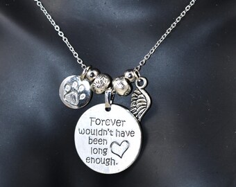 以下が含まれることがあります： 「Forever wouldn't have been long enough.」と書かれたチャームが付いたシルバーネックレス。チャームには小さなハートが付いています。ネックレスには、肉球のチャーム、羽根のチャーム、そしていくつかのシルバービーズも付いています。