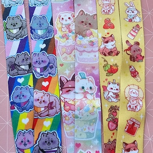 May include: Five colorful lanyards with different designs featuring cute cartoon animals, hearts, and strawberries. The lanyards are made of a soft, woven fabric and are perfect for adding a touch of personality to your keys, ID badge, or other accessories.