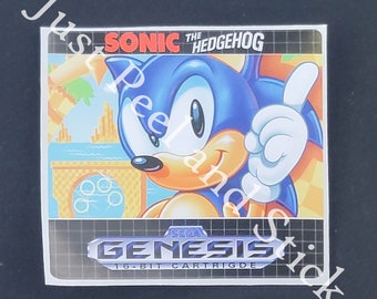 May include: A Sega Genesis game cartridge featuring Sonic the Hedgehog. The blue hedgehog is smiling and giving a thumbs up. The game cartridge is labeled "Sega Genesis 16-Bit Cartridge".