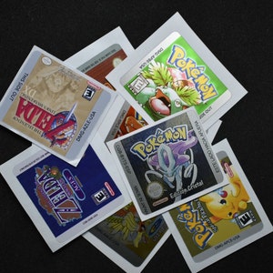 以下が含まれることがあります： ゲームボーイカラー用のゲームカートリッジラベル6枚セット。ラベルはシルバー、ゴールド、ブルーで、さまざまなポケモンキャラクターと「ポケモン」と「ゼルダ」の文字が書かれています。