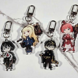 May include: Four acrylic anime-style character keychains with silver-tone clasps. The characters have various hair colors and outfits, and some hold weapons or tools. The keychains are on a white and gray marble-patterned surface.