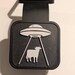 black and white rubber tail hitch cover with a picture of a UFO beaming up a cow