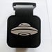 black and white rubber tail hitch cover with a picture of a UFO