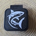 A black and white image of a shark on a black rubber tow hitch cover