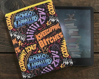 May include: A black fabric e-reader sleeve with a yellow top edge, featuring a colorful graffiti-style print with text including "MONGO IS APPALLED," "KNEECAPPING BITCHES," "HIIIII ZEV!," and "GODDAMNIT DONUT" alongside small crown and foot icons.